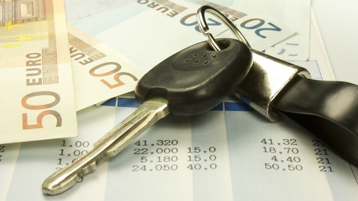 Cle de voiture entouree de billets et d'une facture