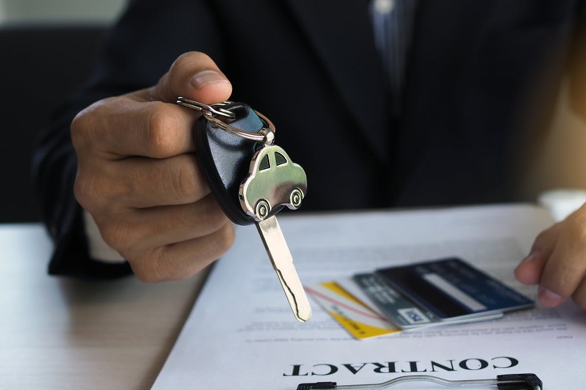Vendeur de voiture tendant une cle