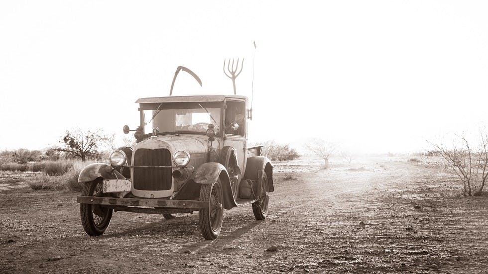 Voiture ancienne roulant sur une route deserte