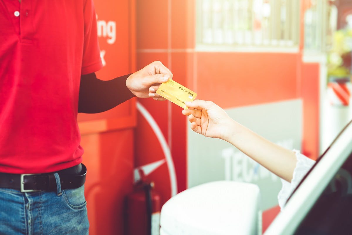 Conductrice tendant sa carte de credit a un pompiste