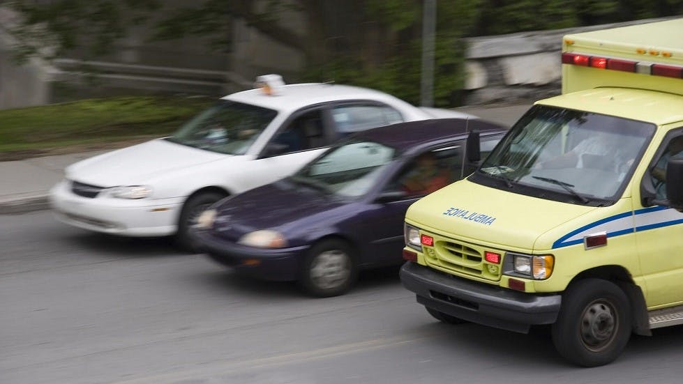 Taxi depasssant une automobile et une ambulance par la droite