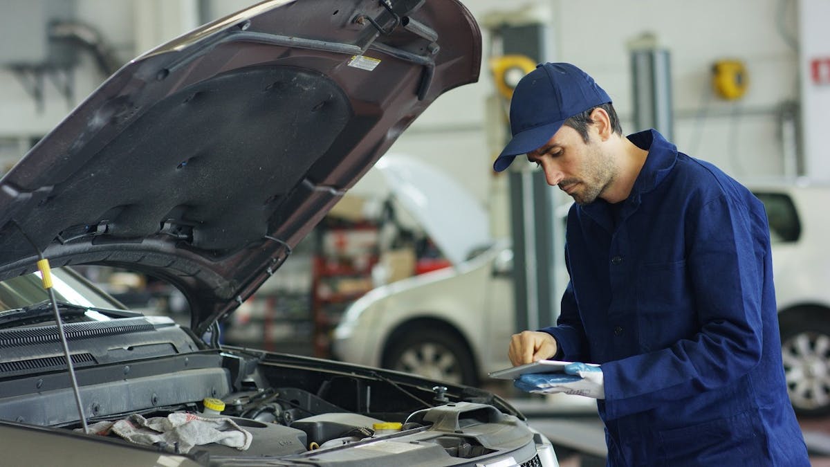 Mecanicien realsisant un controle technique sur une voiture