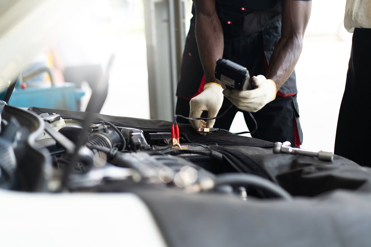 Garagiste testant la batterie d'une voiture