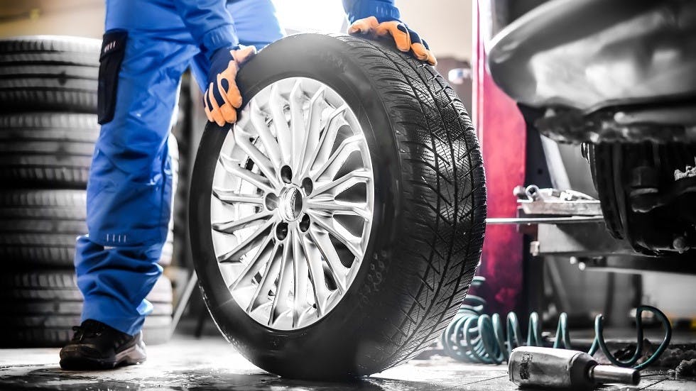Garagiste installant des pneus neufs sur une voiture