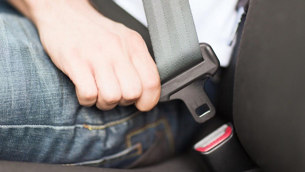 Usager de la route ajustant sa ceinture de sécurité
