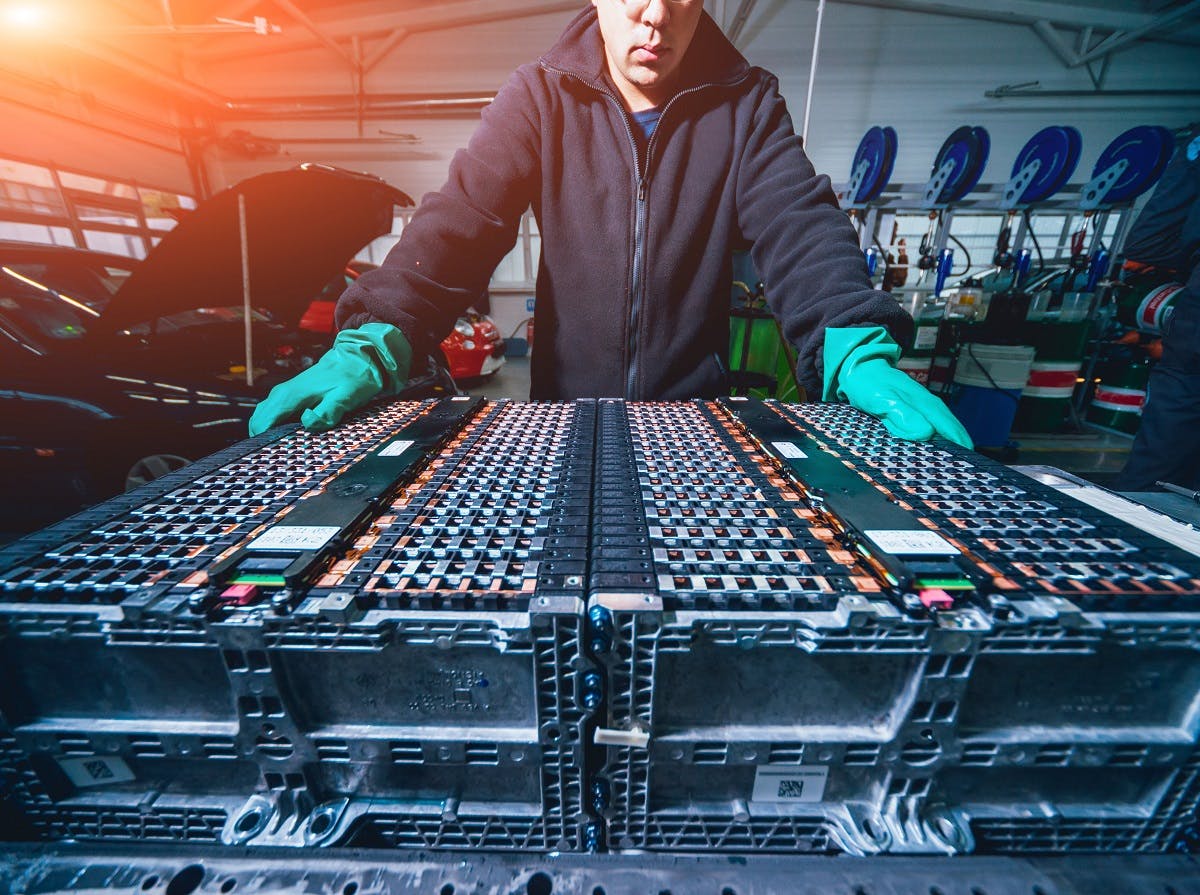 Mecanicien inspectant batterie voiture electrique