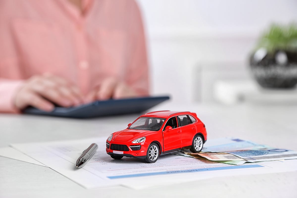 Petite voiture rouge et billets
