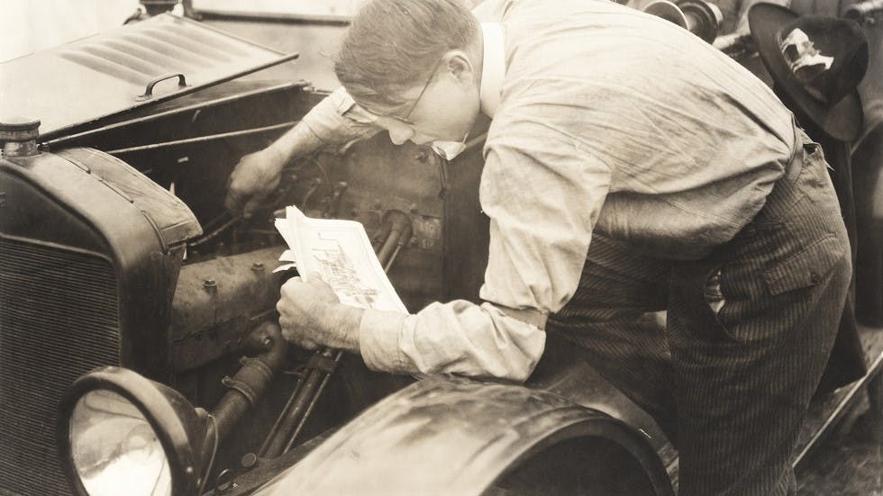 Conducteur lisant les instructions pour reparer son moteur