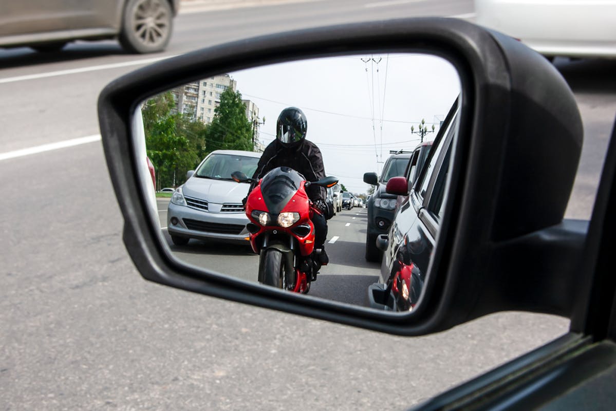 Motard dans le rétroviseur d'un automobiliste