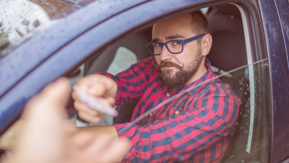 Usager tendant son permis de conduire a un agent de police