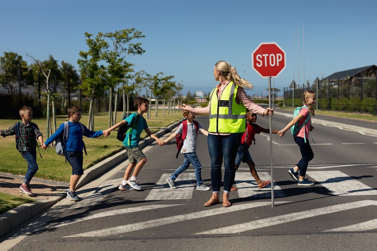 Groupe d enfants traversant derrière une enseignante