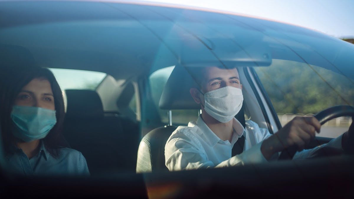 Deux usagers portant des masques dans une voiture