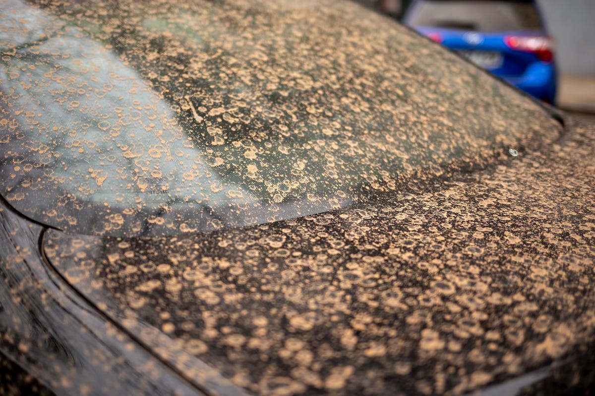 Voiture noire recouverte de sable du Sahara