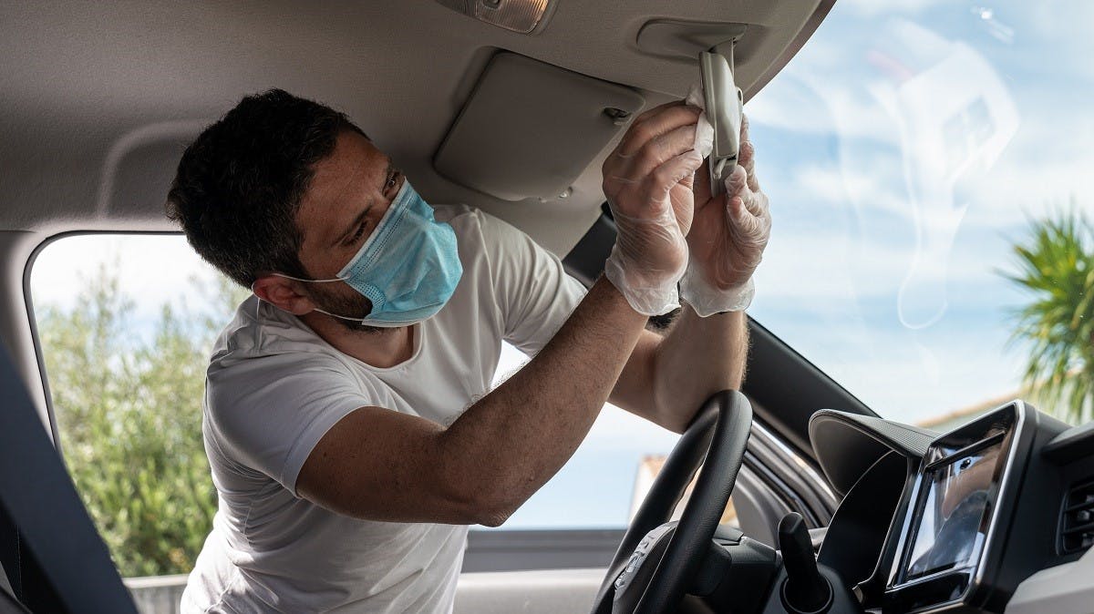 Conducteur nettoyant l'interieur de son vehicule durant la crise sanitaire