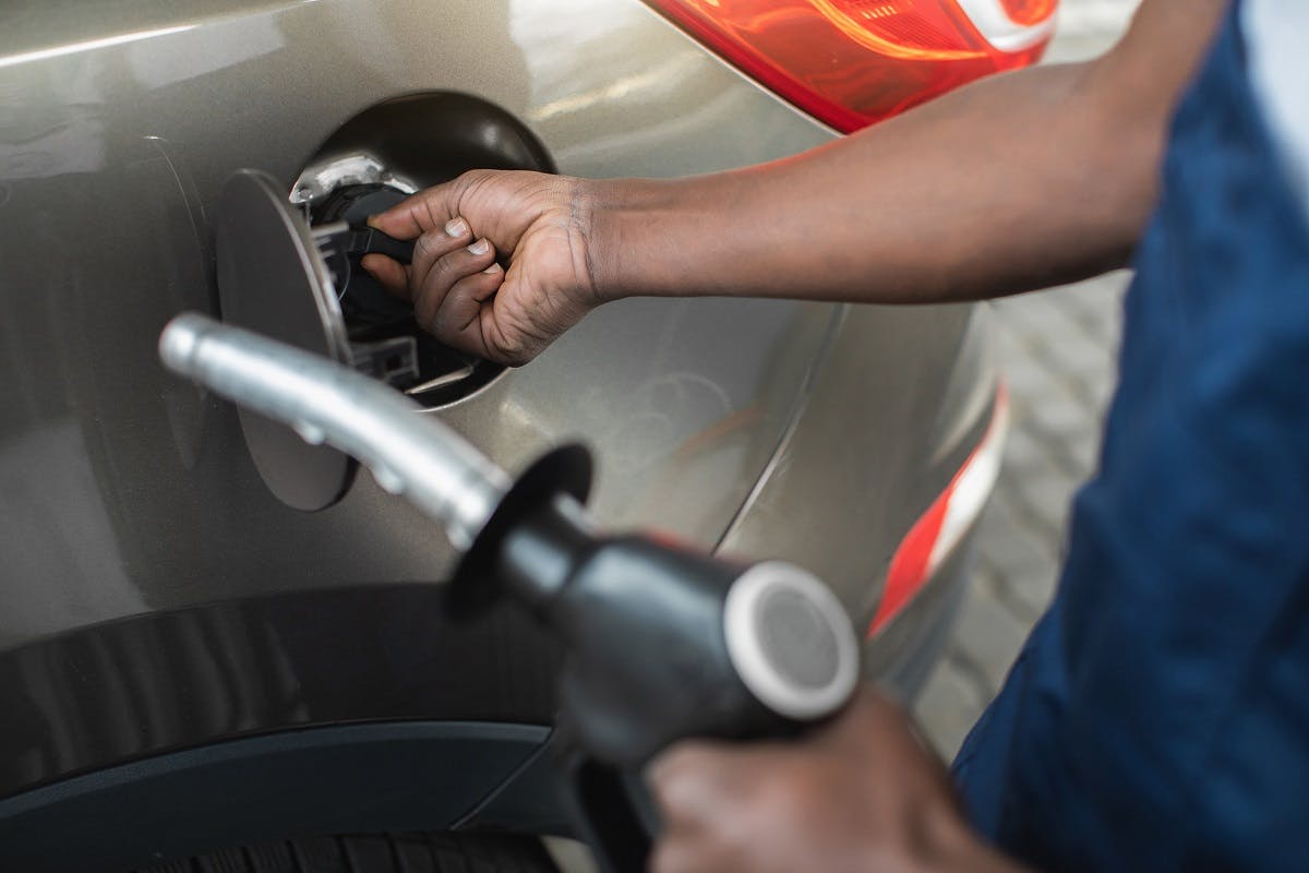 Automobiliste retirant le bouchon du reservoir de carburant