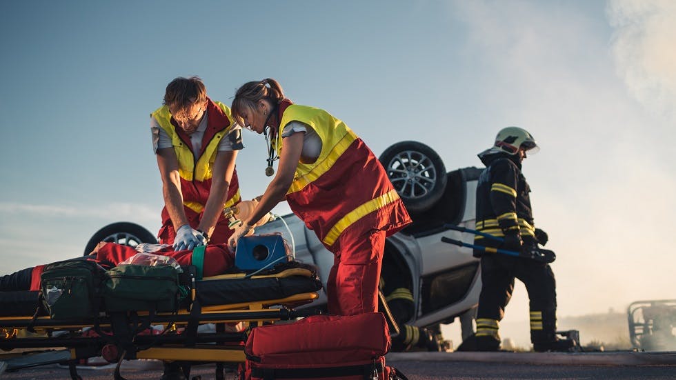 Ambulanciers secourant la victime d'un accident de voiture