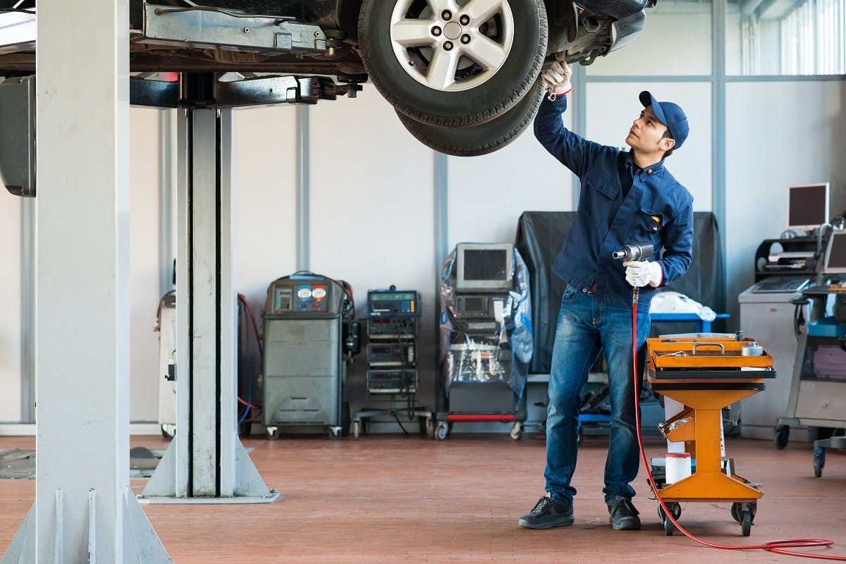 Garagiste realisant la revision d une voiture