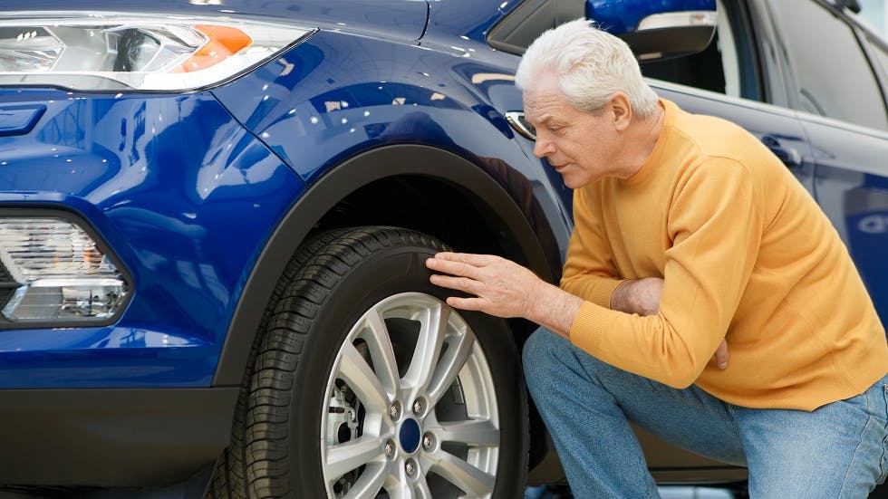 Usager inspectant les informations sur les flancs de ses pneus