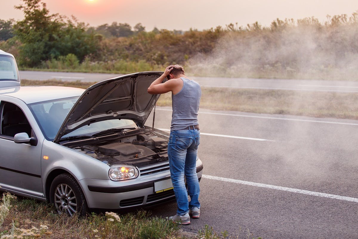 Automobiliste devant sa voiture en panne
