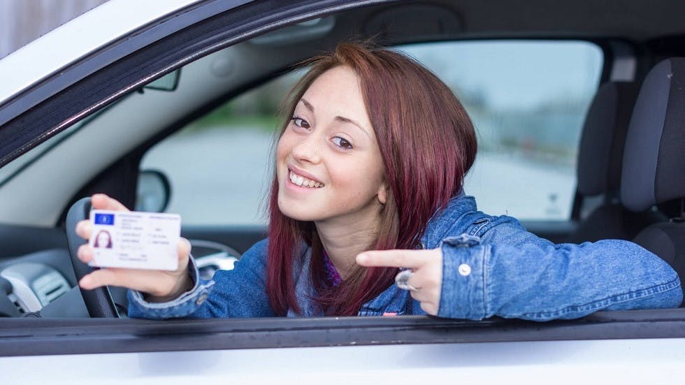 Jeune conductrice presentant son permis de conduire