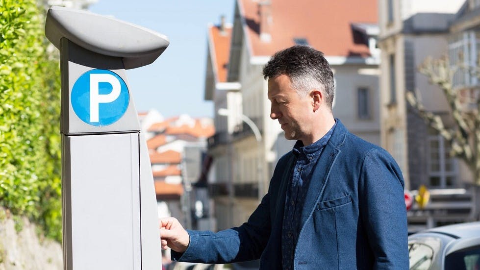 Usager payant pour son stationnement sur un horodateur