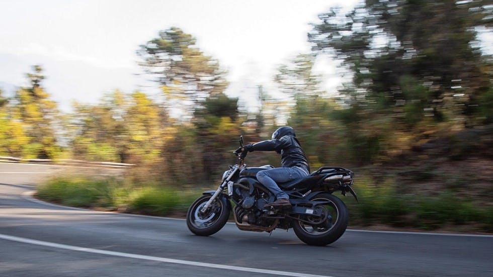Motard circulant sur une route de foret