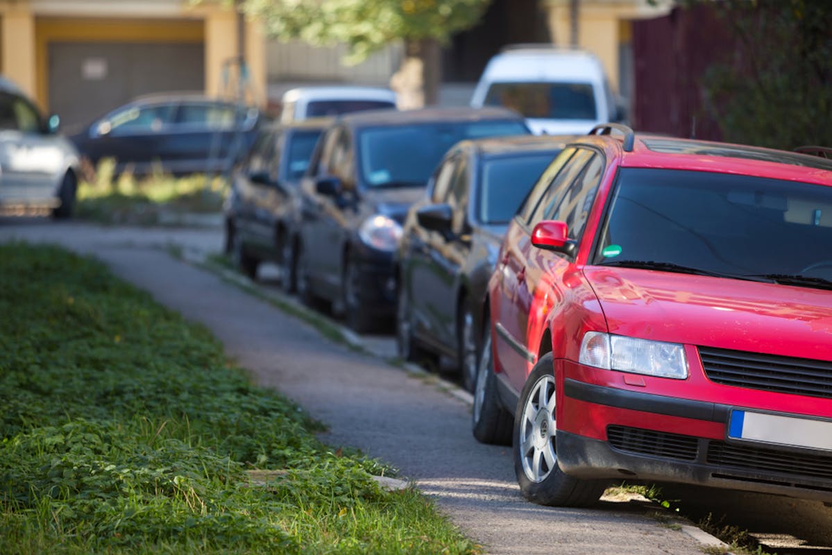 Voiture rouge garée sur un trottoire