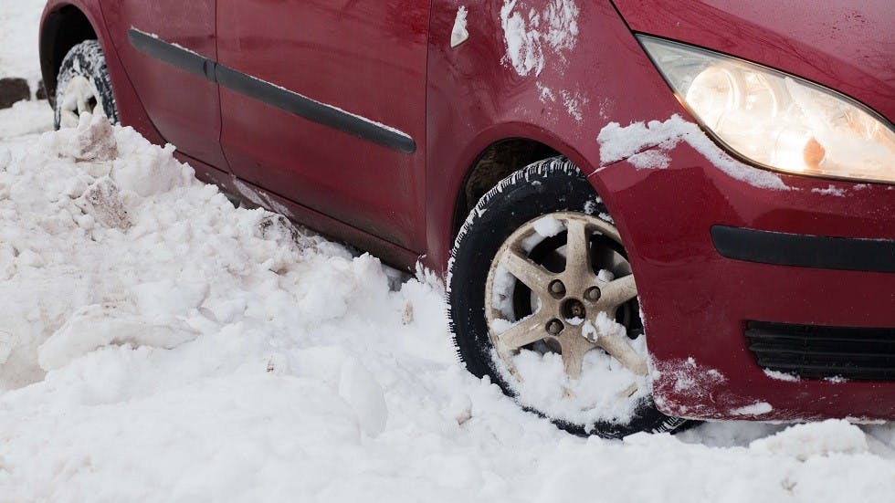 Roues braquees d'une automobile coincee dans la neige