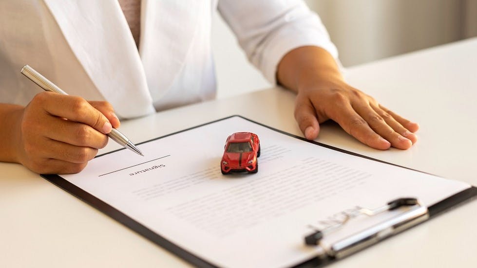 Usager signant un contrat d'assurance auto