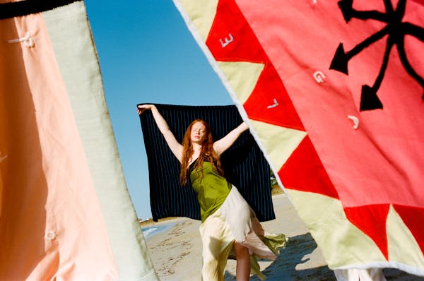 A model is seen posing surrounded by Pangea flags. | © Pangea 2023