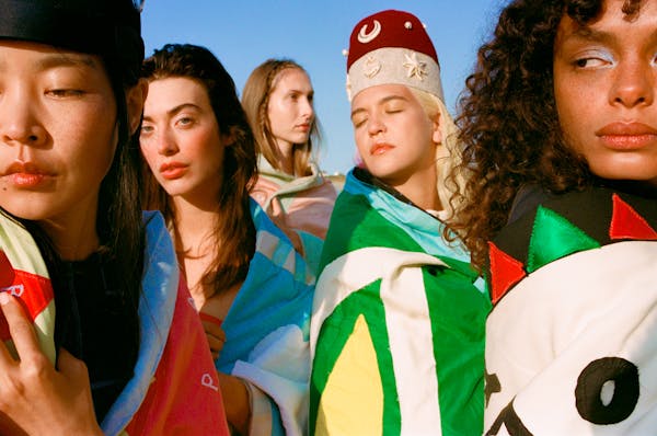 Models pose together with Pangea flags wrapped around their bodies.  | © Pangea 2023