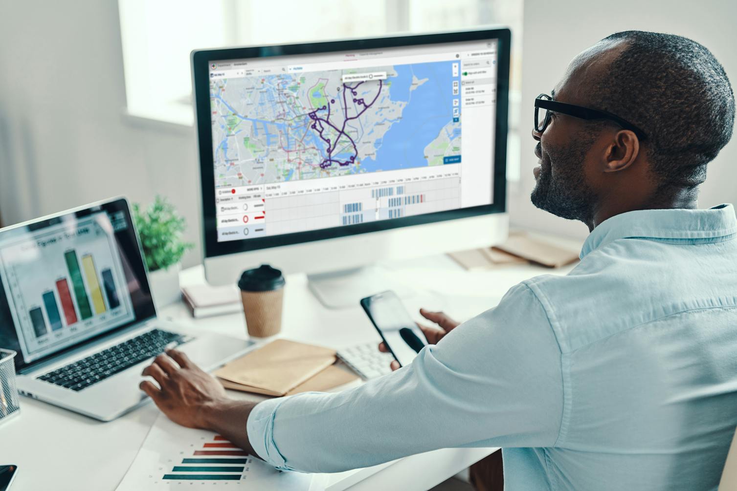 A guy behind a computer screen working with Route optimization software
