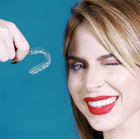 Femme tenant une gouttière dentaire transparente Orthlane