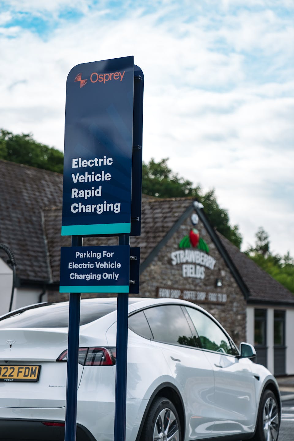 Osprey rapid chargers charging a white Tesla.