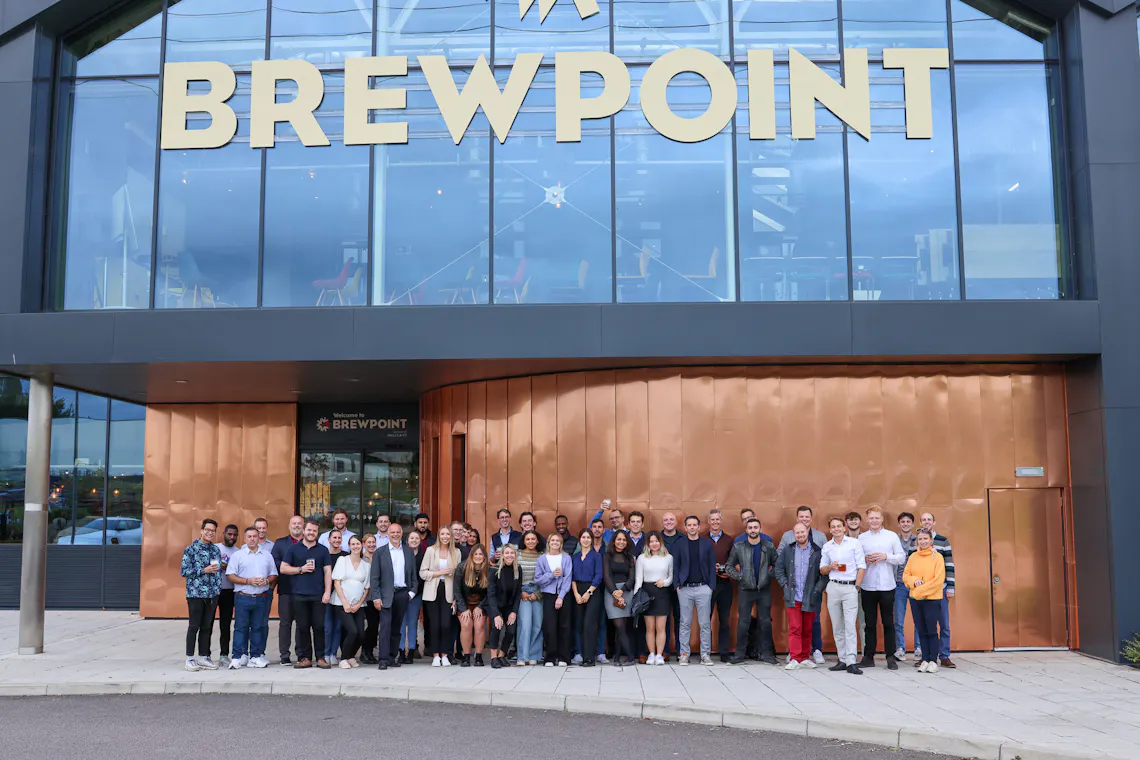 A large group of people stand in front of a building