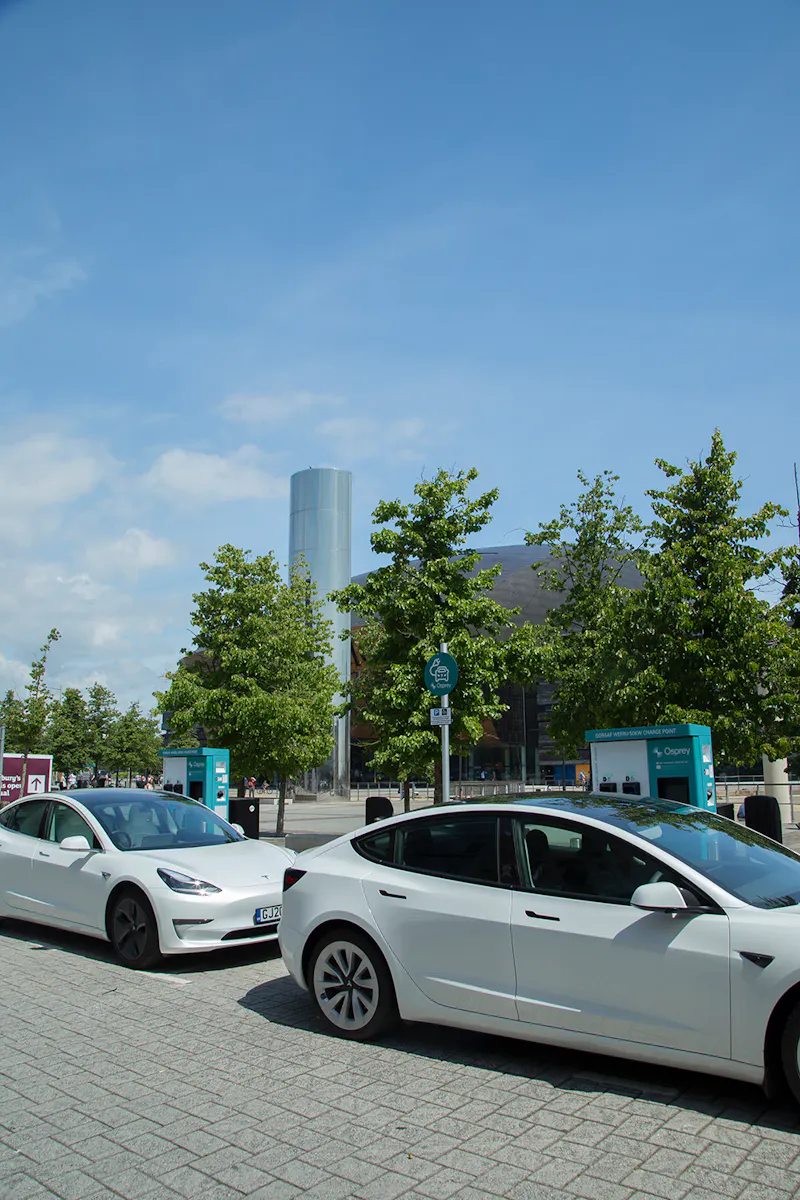 Two white Teslas charging at Cardiff Council branded 50kW Osprey EV charging station