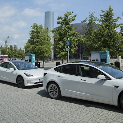Two white Teslas charging at Cardiff Council branded 50kW Osprey EV charging station