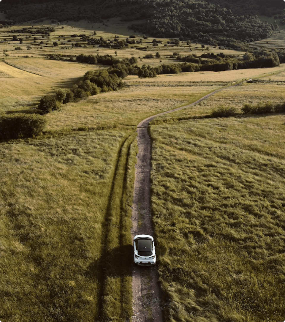A birds eye view of an electric car driving through a field