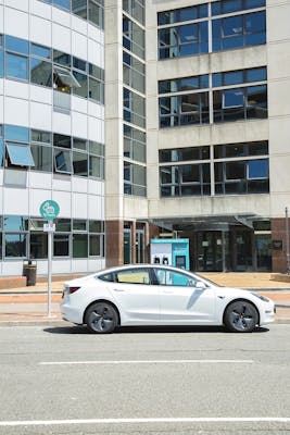 A white Tesla plugged into a Cardiff Council branded 50kW Osprey car charging station