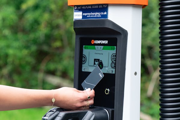 Person paying for their car being charged by a Osprey EV rapid charger.