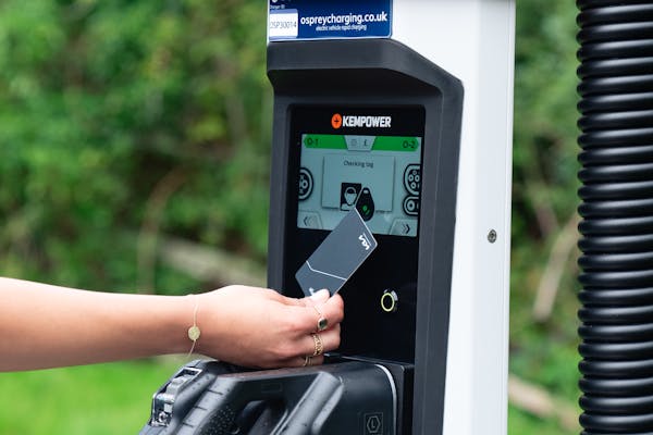 Person paying for their car being charged by a Osprey EV rapid charger.