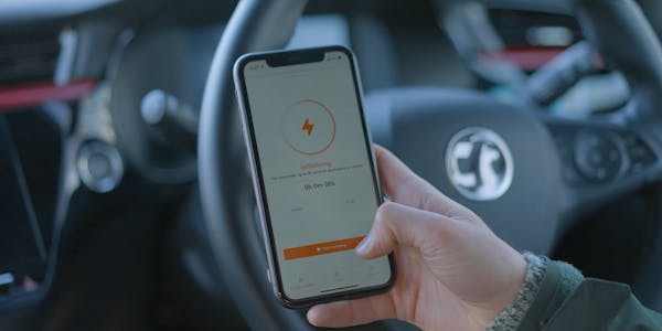 A hand holding a smart phone showing a charging session starting on the Osprey EV charging app