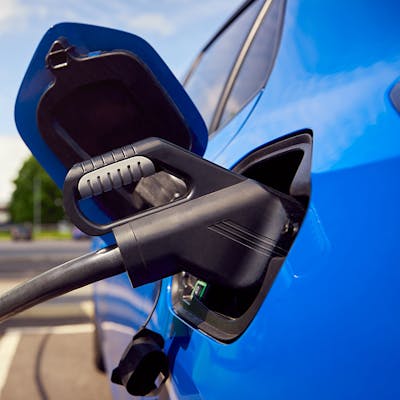 A CCS charging cable plugged into a blue electric vehicle