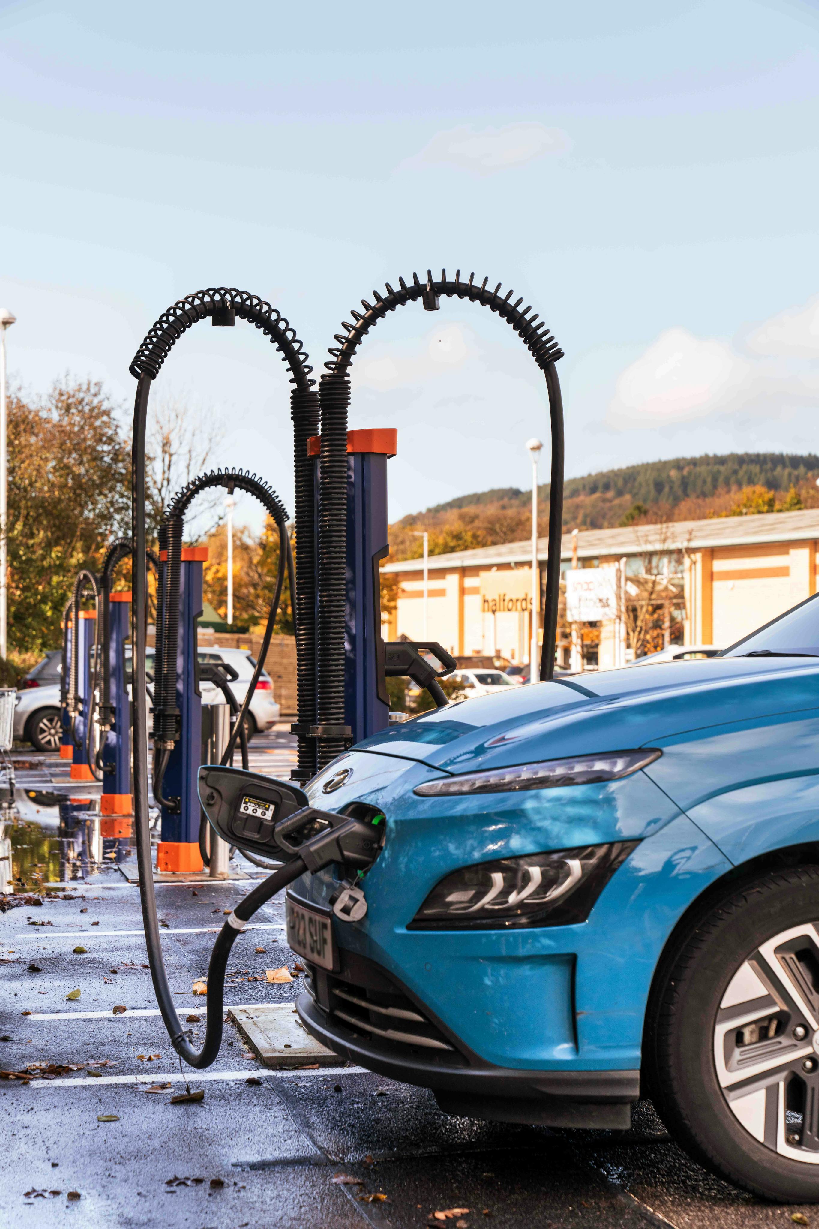 A blue electric car charging at an Osprey rapid chargepoint