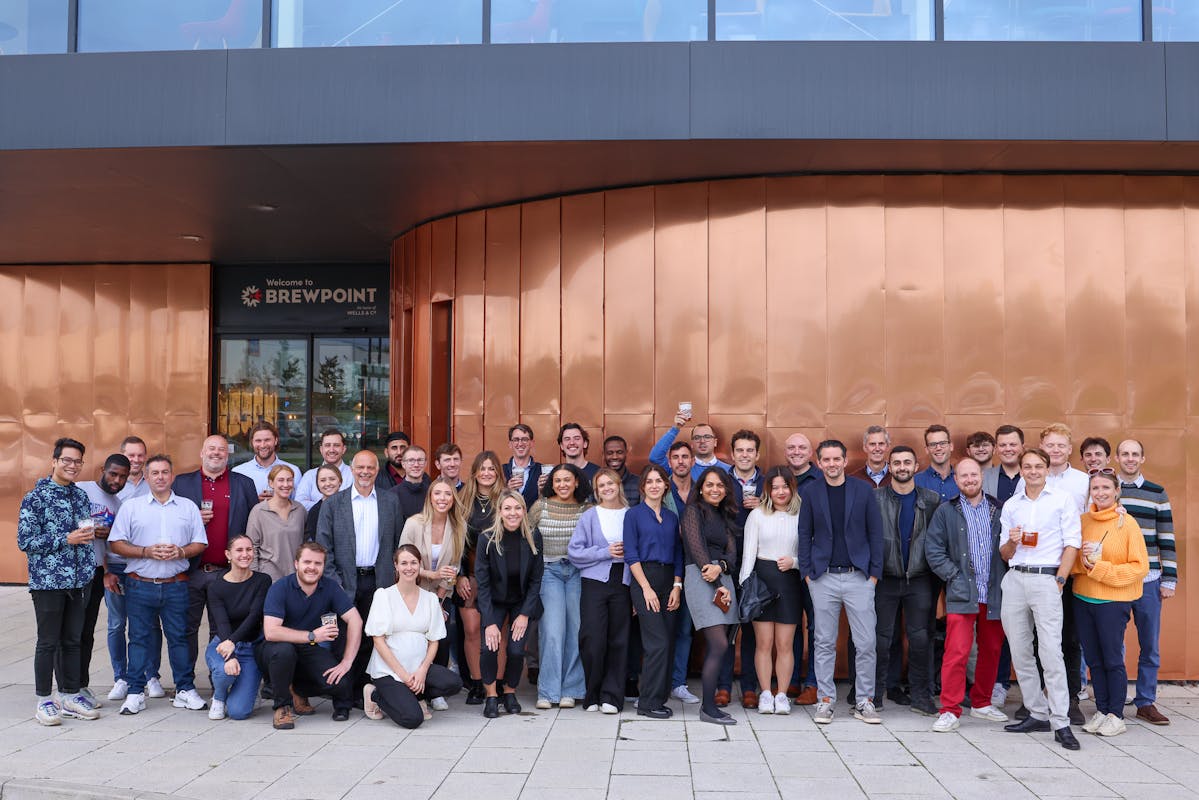 A large group of people stand in front of a building