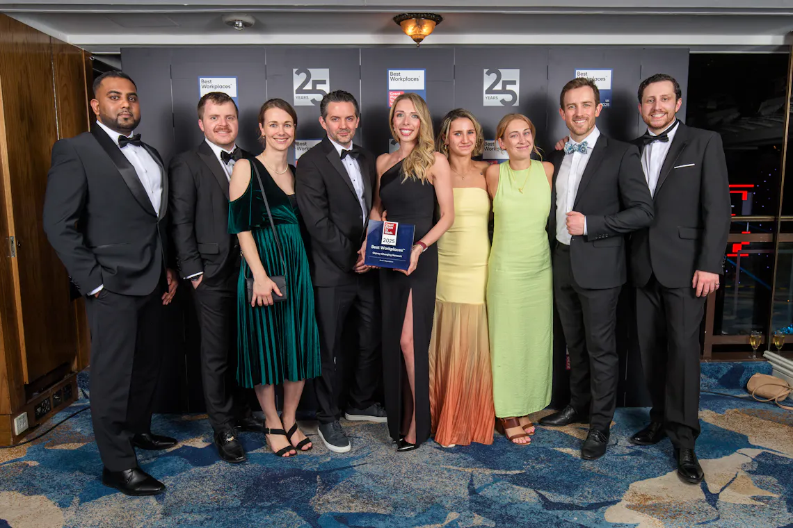 A group of people dressed up posing for a photo with a trophy