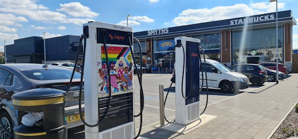 Two 75kW chargers side by side in front of a Starbucks. One charger features eye-catching Pride artwork.