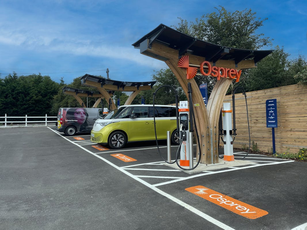 Two electric vans parked at an Osprey electric vehicle charging hub