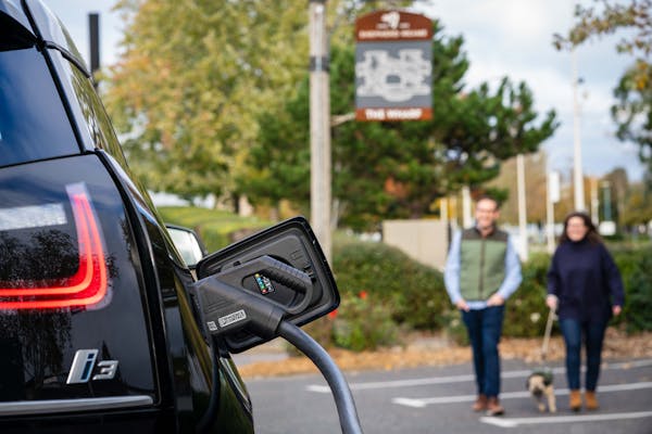 Couple returning to their charging car from the Shepherd Neame pub.