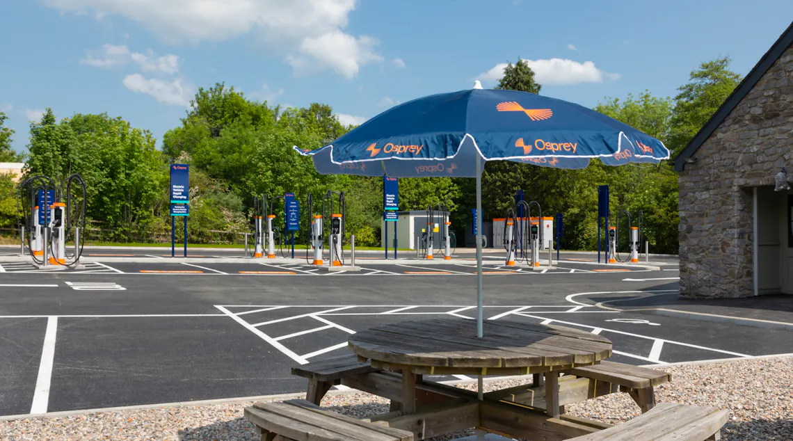 A picnic table located in front of a high-powered EV charging hub.